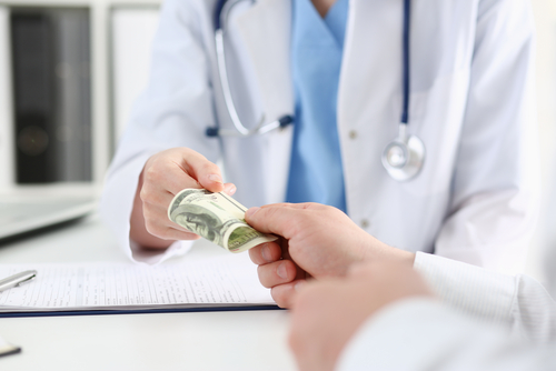 patient handling money to the doctor