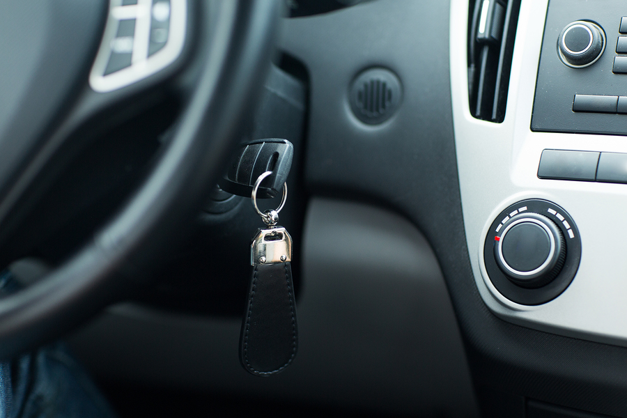 transportation and ownership concept - car key in ignition start lock