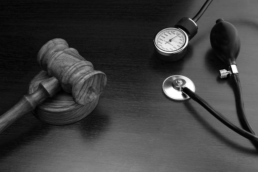 Judges Gavel And Medical Equipment On Black Wooden Background