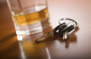 glass of alcohol beside car  keys