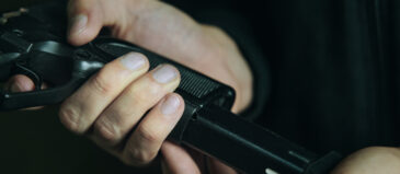 man putting cartridge in handgun