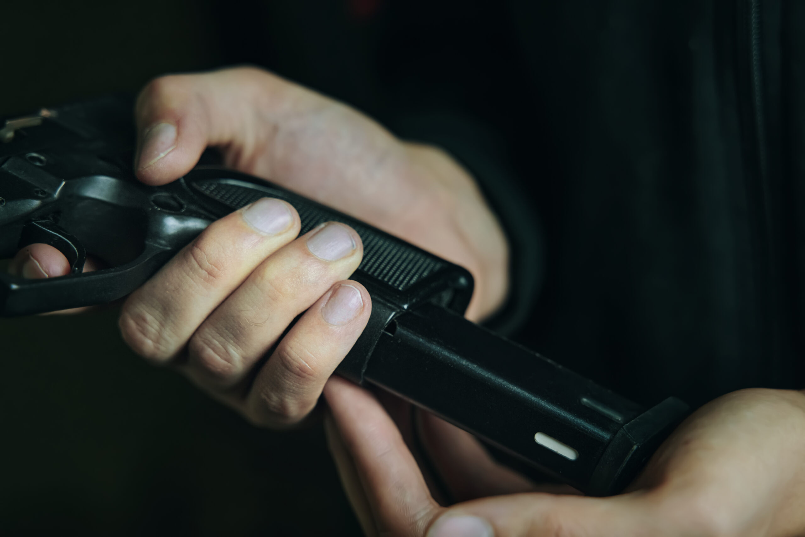 man putting cartridge in handgun